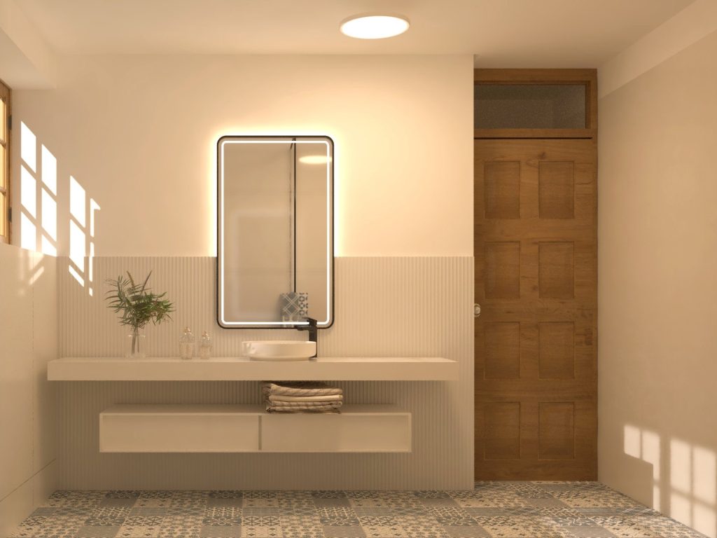 Lavatório de pousar em bancada branca com espelho retroiluminado e porta em madeira.